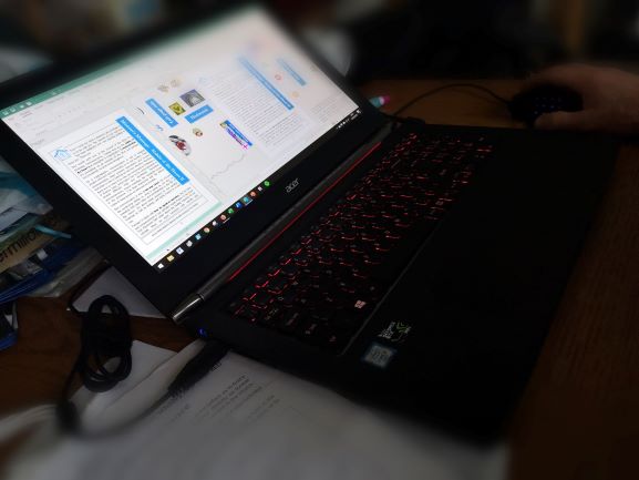 laptop showing desktop publishing software editing magazine